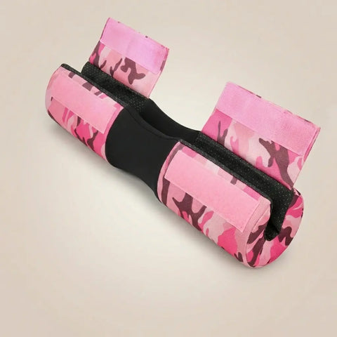 Celvian barbell pad in rose quartz camo shown from an angled top view, featuring a pink camouflage outer, black center groove, and pink hook-and-loop straps.