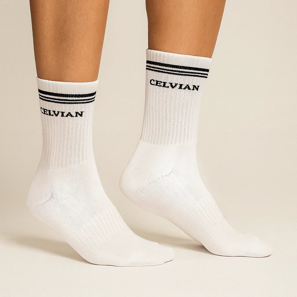 Celvian white crew socks with black logo and double stripe design, side view on model showcasing ribbed cotton texture and snug athletic fit.