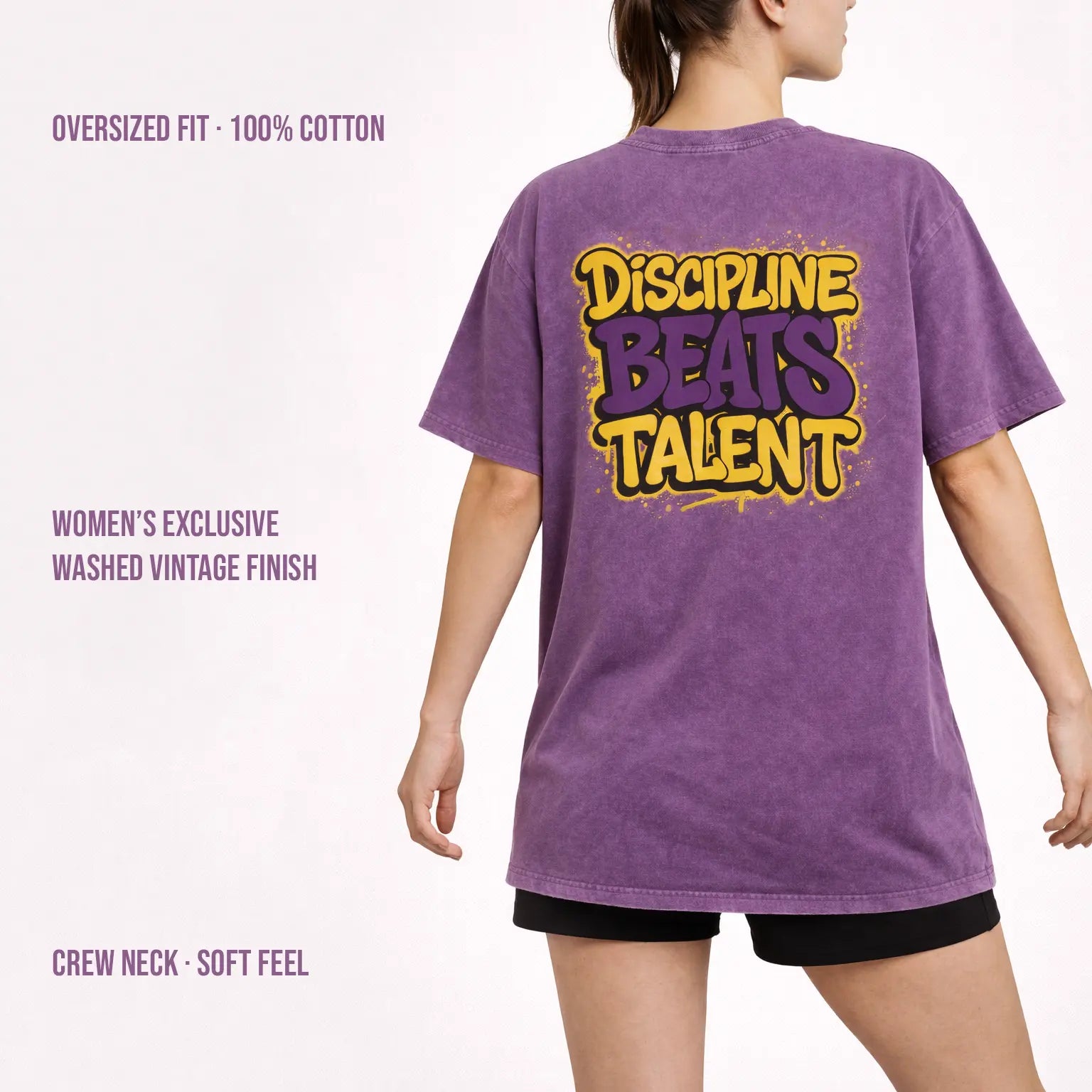 Woman wearing purple washed oversized t-shirt with ‘Discipline Beats Talent’ back print, 100% cotton vintage finish.