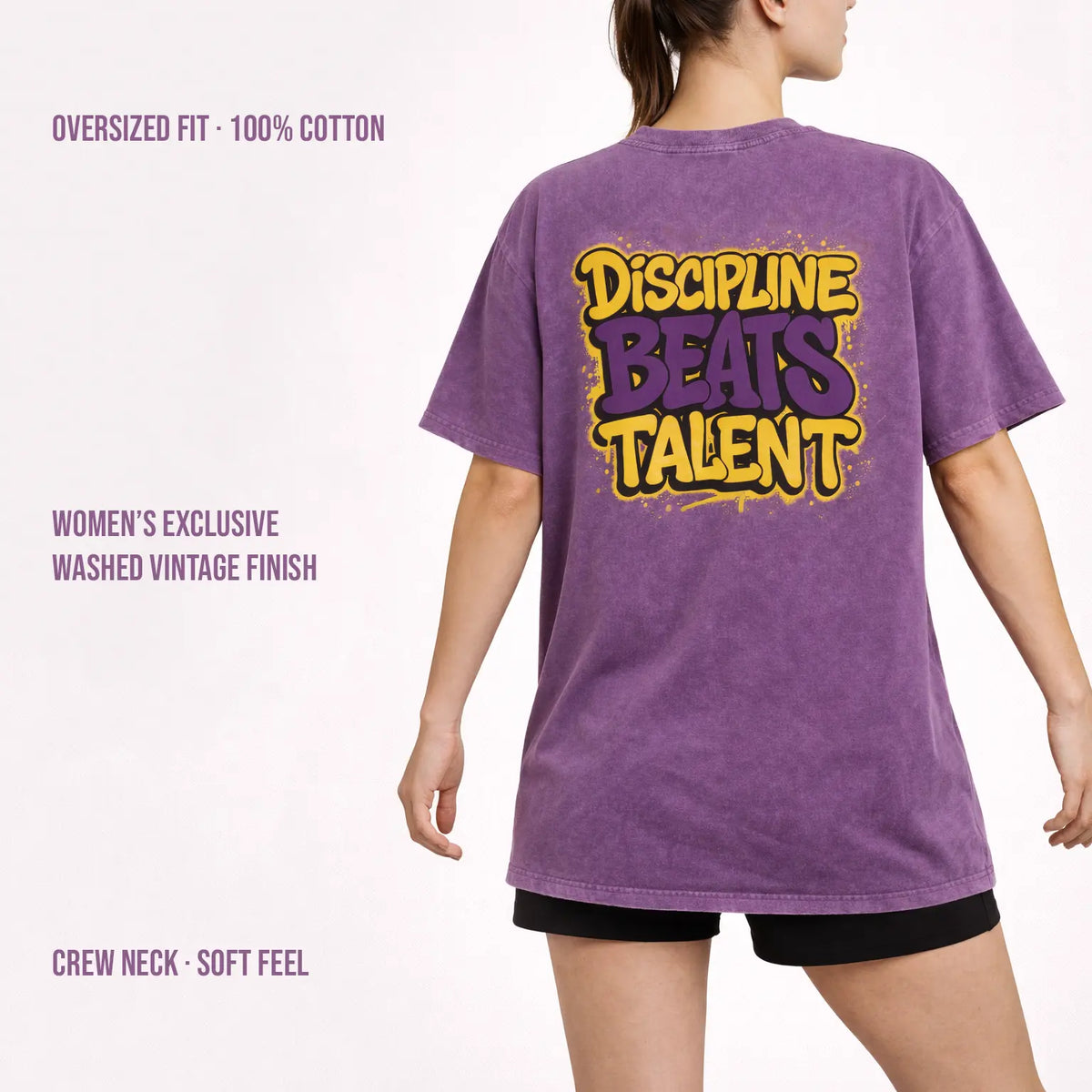 Woman wearing purple washed oversized t-shirt with ‘Discipline Beats Talent’ back print, 100% cotton vintage finish.