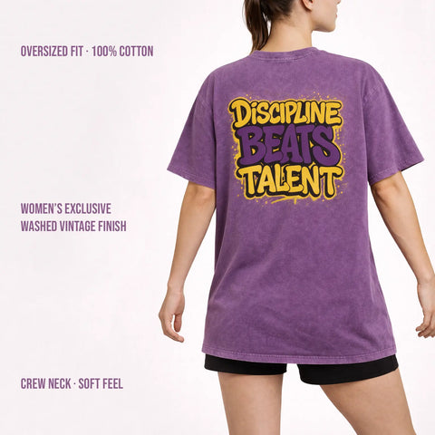 Woman wearing purple washed oversized t-shirt with ‘Discipline Beats Talent’ back print, 100% cotton vintage finish.