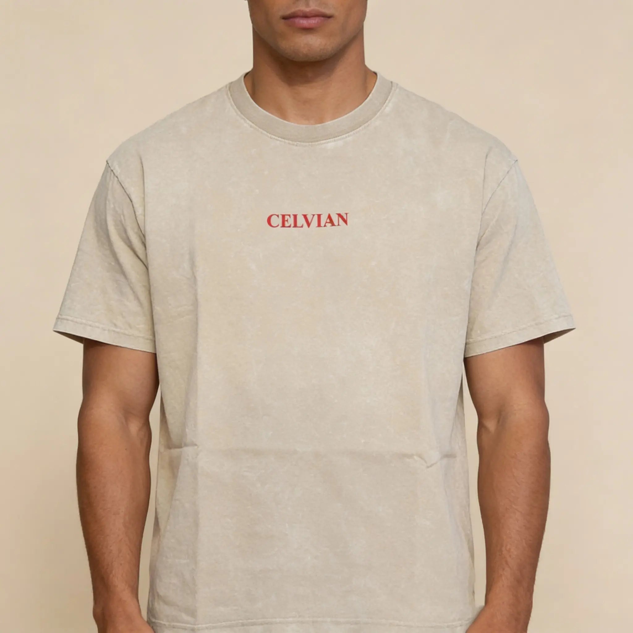 Front view of beige washed oversized t-shirt with small red Celvian logo on chest.