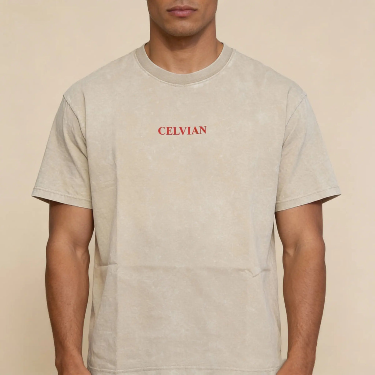 Front view of beige washed oversized t-shirt with small red Celvian logo on chest.