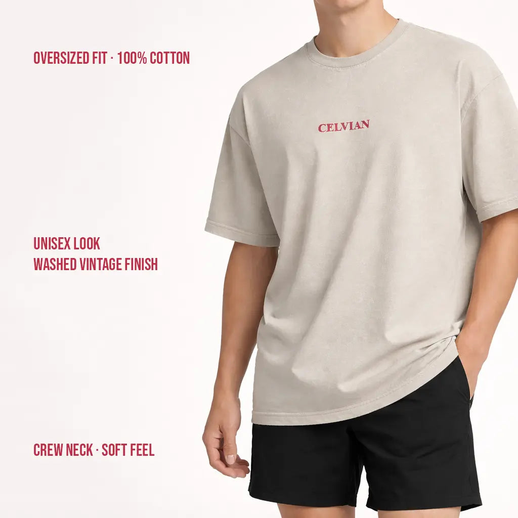 Model wearing beige washed oversized Celvian t-shirt with small red chest logo, 100% cotton vintage finish.