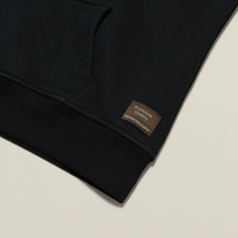 Black Celvian hoodie with a brown label on a beige background