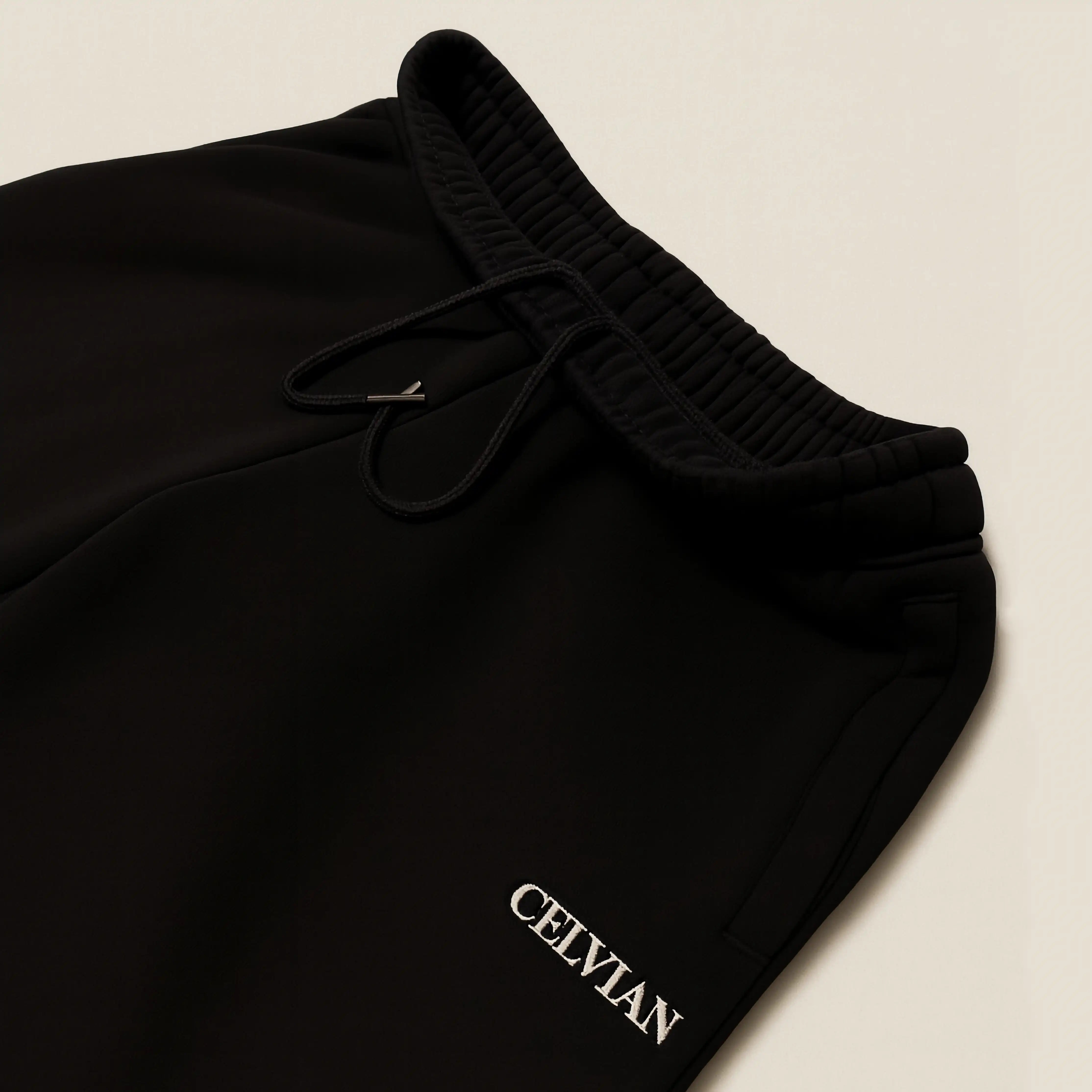 Black pants with 'CELVIAN' branding on a beige background