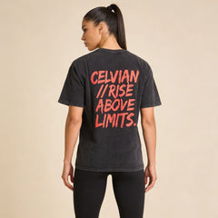 Female model wearing the Celvian No Limits T-Shirt in washed black, back view with bold red ‘CELVIAN // RISE ABOVE LIMITS.’ graphic and oversized fit.