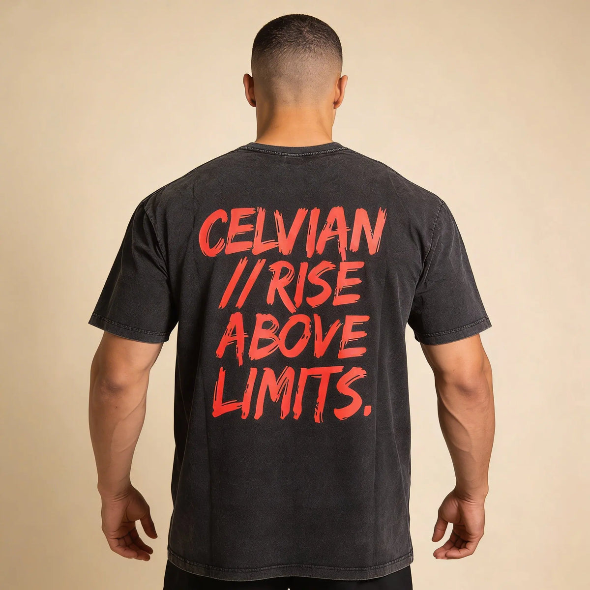 Back view of a man wearing the Celvian No Limits T-Shirt in washed black, featuring the bold red ‘CELVIAN // RISE ABOVE LIMITS.’ back graphic and oversized fit.