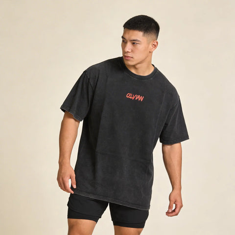 Front view of a man wearing the Celvian No Limits T-Shirt in washed black, featuring a small red CELVIAN chest logo and oversized fit.
