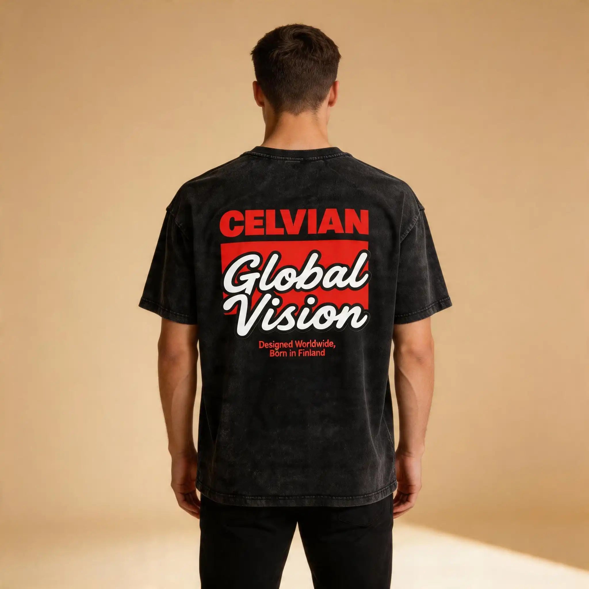 Male model wearing the Celvian Obsidian Global Vision T-Shirt in a washed black finish, shown from the back with the large red, white, and black Global Vision graphic in a clean studio setting.