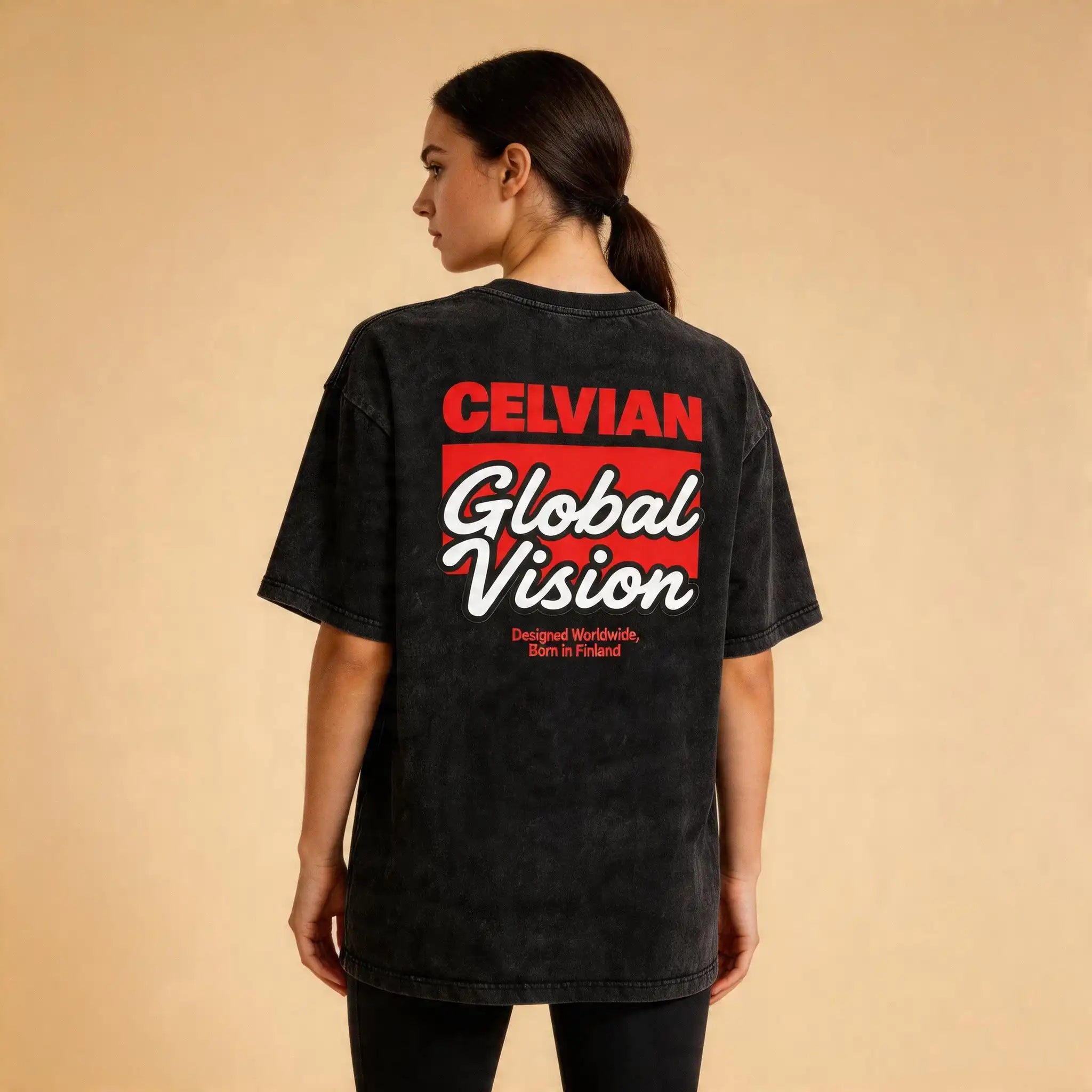 Female model wearing the Celvian Obsidian Global Vision T-Shirt in a washed black finish, shown from the back with the bold red and white Global Vision graphic on a clean studio background.