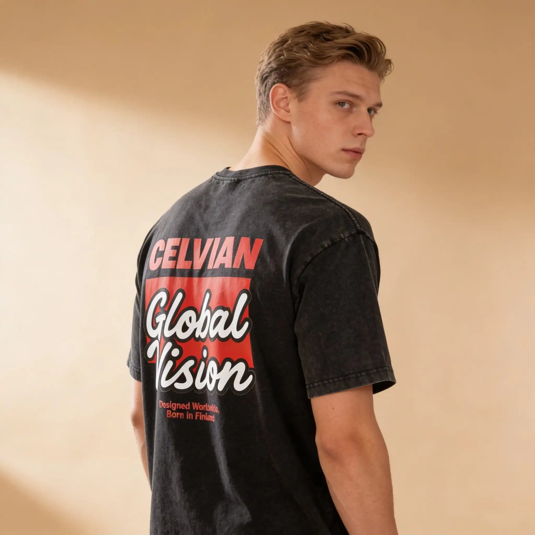 Male model wearing the Celvian Obsidian Global Vision T-Shirt in a washed black finish, shown in a back three-quarter view with the large red and white Global Vision graphic visible.