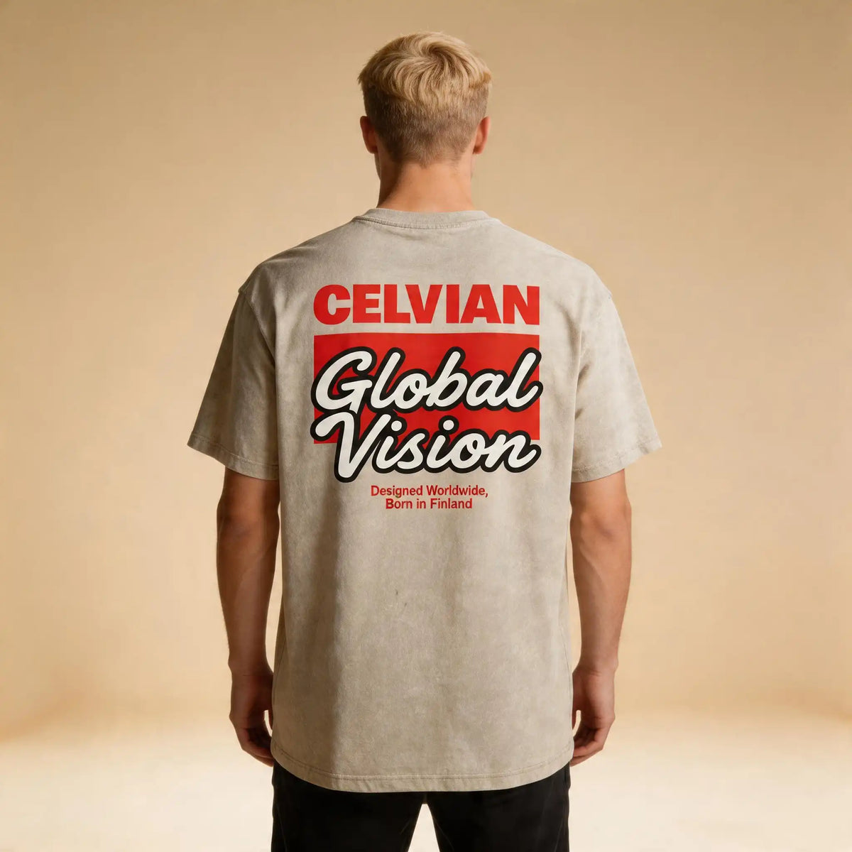 Male model wearing the Celvian Sandstone Global Vision T-Shirt in a washed beige finish, shown from the back with the large red and white Global Vision graphic and oversized fit.