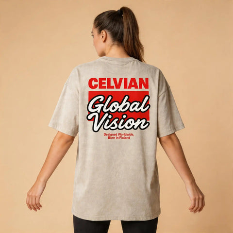 Female model wearing the Celvian Sandstone Global Vision T-Shirt in a washed beige finish, shown from the back with an oversized fit and bold red and white Global Vision graphic.